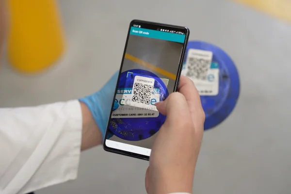 Technician scans an EcoGSE QR code on a pest device to log service data in a South African food facility.